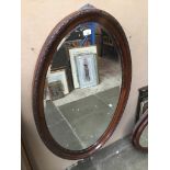 An Edwardian oval mirror.