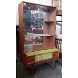 A retro teak display cabinet with sliding glass doors.