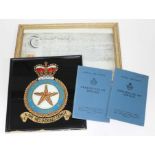 An RAF reverse painted glass panel and two Certificate of Service booklets together with an