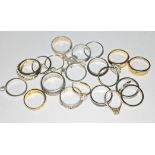 A box of various rings including white and yellow metal rings.