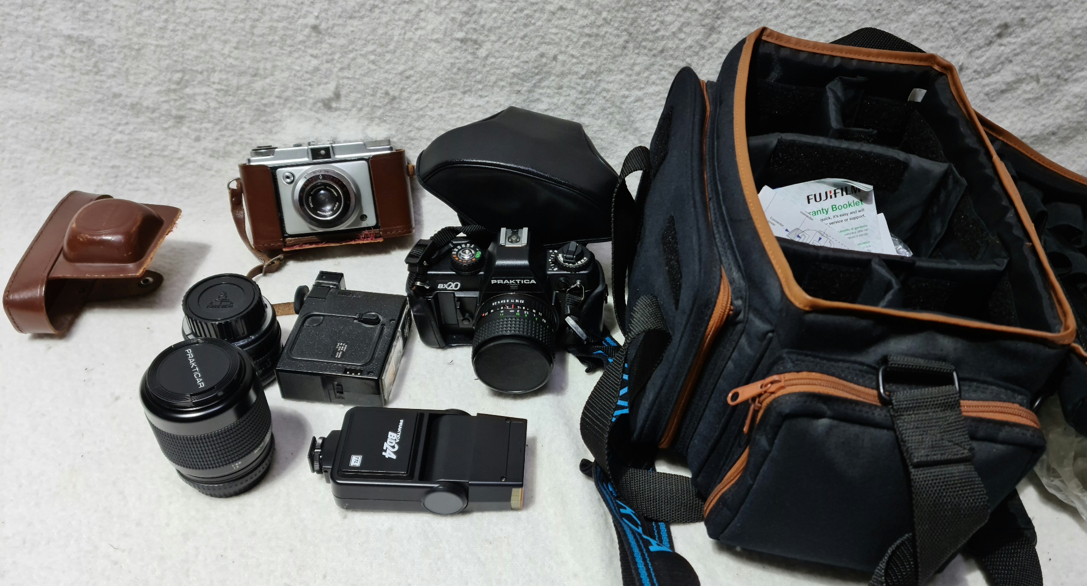A Praktica Bx20 with lenses and flash in bag and a Iford sportsman vintage camera