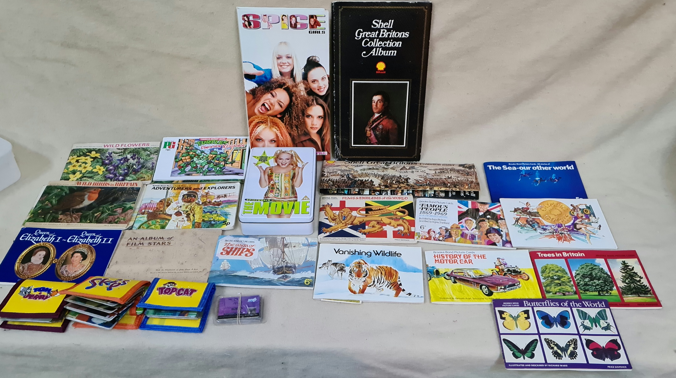 A box containing various collector card books, Spice Girls postcard album and tin, 3 skips