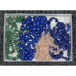 A tray of assorted beads comprising aventurine quartz, rose quartz and lapis lazuli.