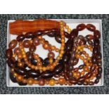 A tray of assorted plastic butterscotch coloured beads and a bracelet.