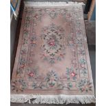 A Chinese wool carpet, pink ground decorated with flowers, 200cm x 120cm (approx).