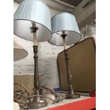 A pair of metal lamps with shades.