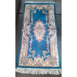 An oriental Kayam wool carpet, blue ground decorated with flowers, 190cm x 90cm (approx).