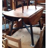 An Ercol elm drop leaf dining table with painted legs.