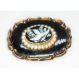 A 19th century mourning brooch, the central oval agate cameo surrounded by a row of pearls, enamel