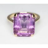 An amethyst ring, the rectangular cut stone weighing approx. 9.84 carats, band marked '9ct', gross