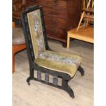 A Victorian Aesthic style ebonised nursing chair, the back with Moorish style carvings, the seat