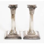 A pair of Victorian silver candlesticks, corinthian column form with square stepped bases, sponsor's