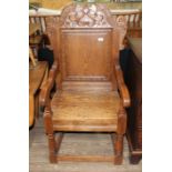 A reproduction carved and joined oak Wainscot armchair by Taylor's, width 65cm, depth 60cm &