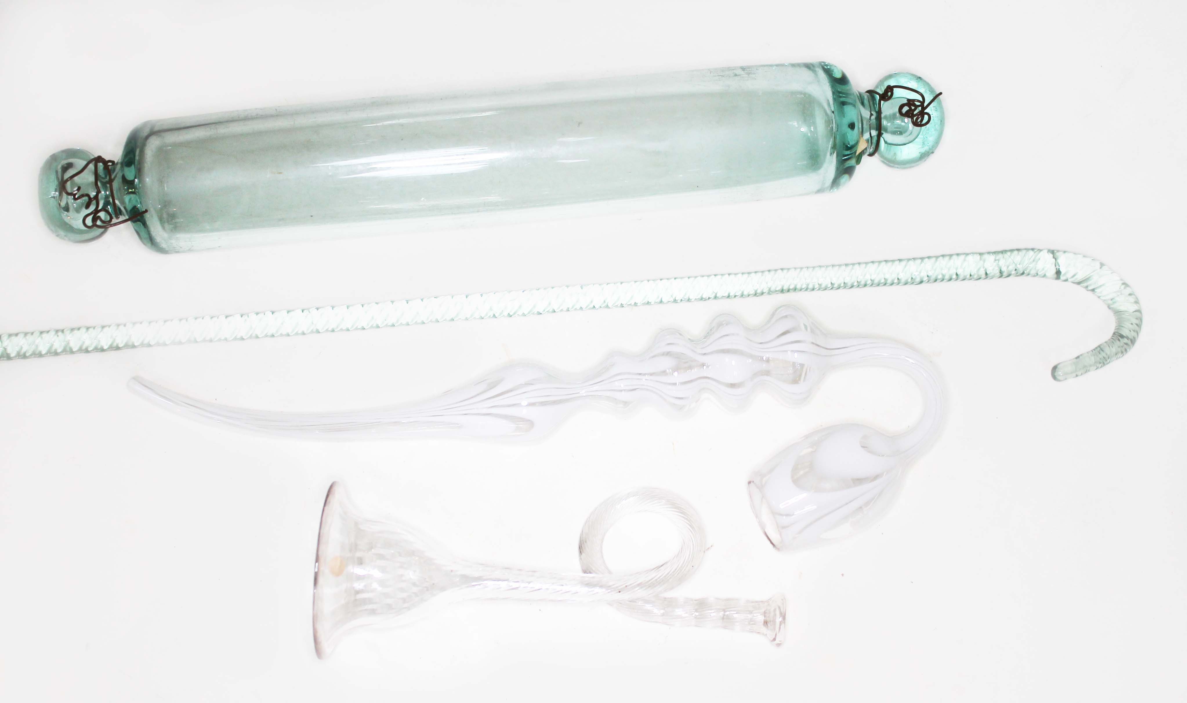 Four pieces of 19th century glass comprising a Nailsea type pipe, a twist cane, a rolling pin and