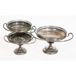 A set of three matching silver tazzas, each with twin handles and pierced border, pedestal bases,