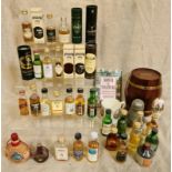 A collection of miniature alcoholic bottles, a wooden barrel money box and a pewter salt and