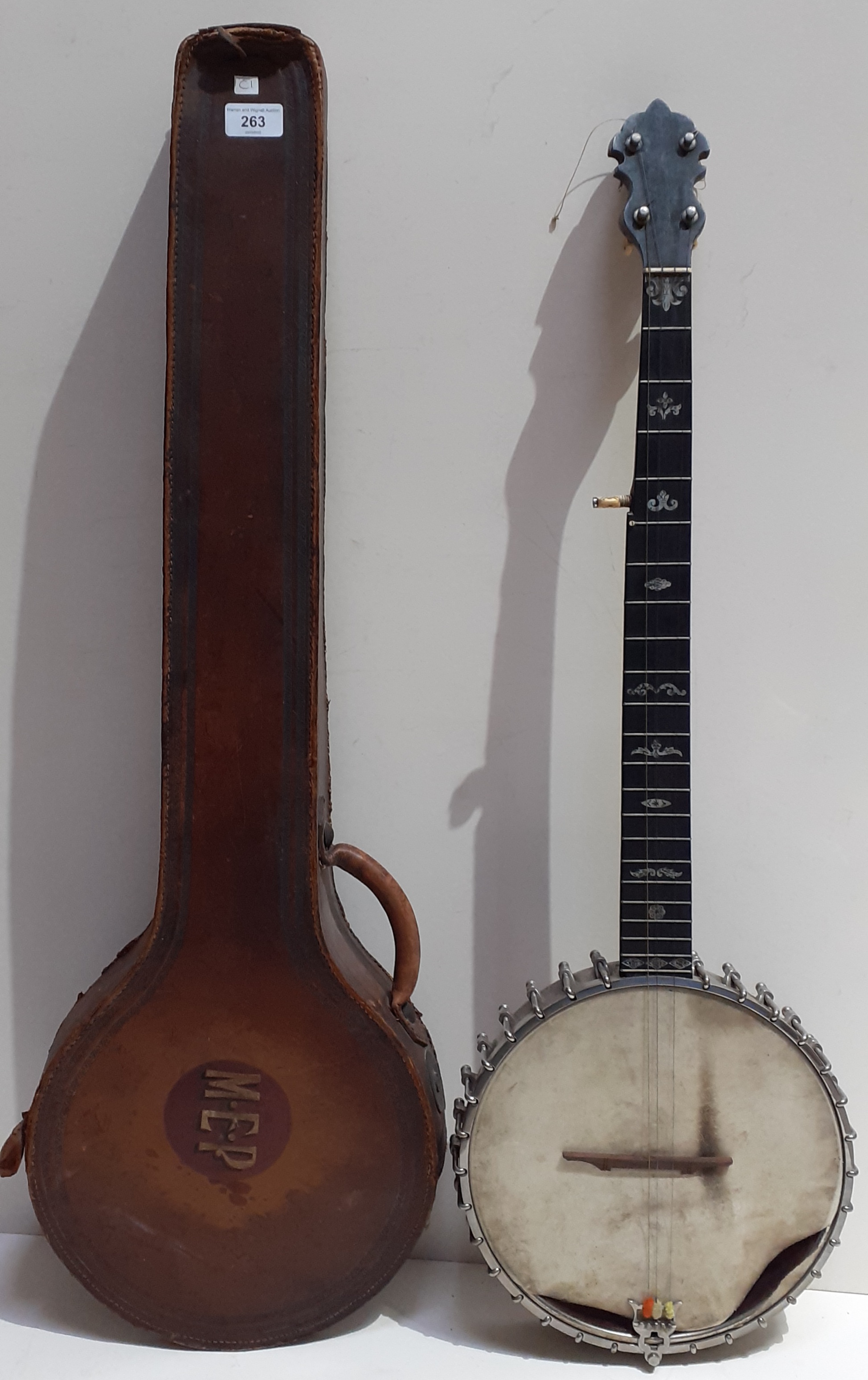 A vintage banjo in leather case, marked Richard Spencer Clapham. Condition:- General wear through