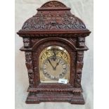A carved oak cased mantle clock.
