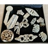 A black display box containing various paste, rhinestone, Art Deco style dress clips, duettes, etc.
