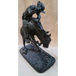 A bronze effect sculpture modelled as a cowboy on a horse.