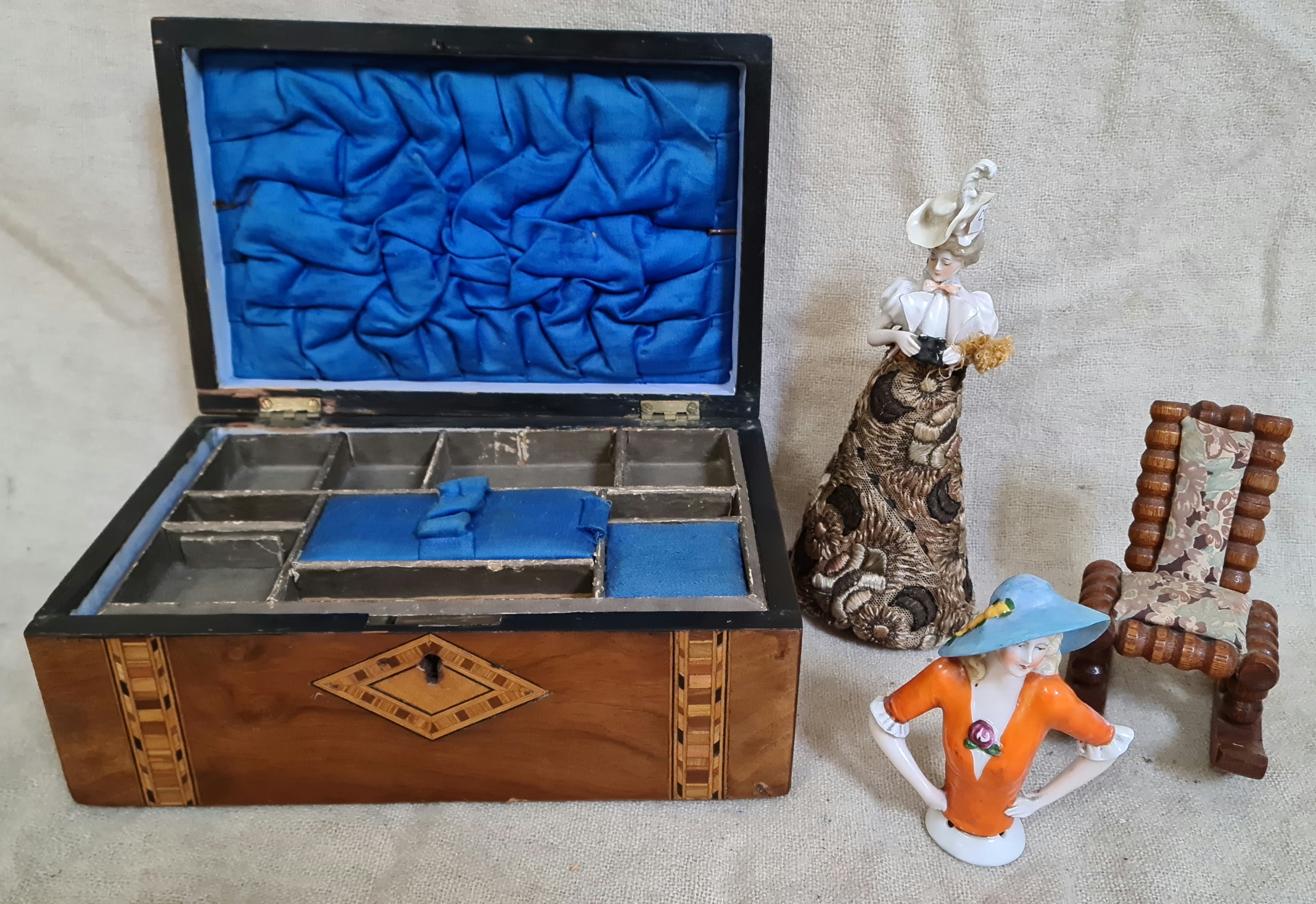 A Victorian inlaid walnut sewing box, two vintage pin cushion dolls and a treen rocking chair pin