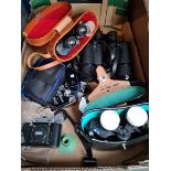 A box containing three sats of binoculars and two camera's