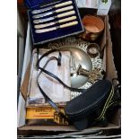 A box containing various items including binoculars, WWI era photographs, plated ware, pewter, Kodak