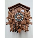 A cuckoo clock with pendulum and weights.