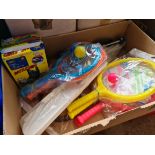 A box of childrens outdoor games including cricket set, bat and ball sets, frisbee, and some shoe