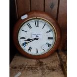 A circular wooden case wall clock with brass rim.