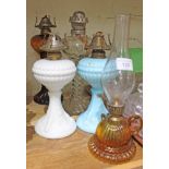 A group of five glass oil lamps.