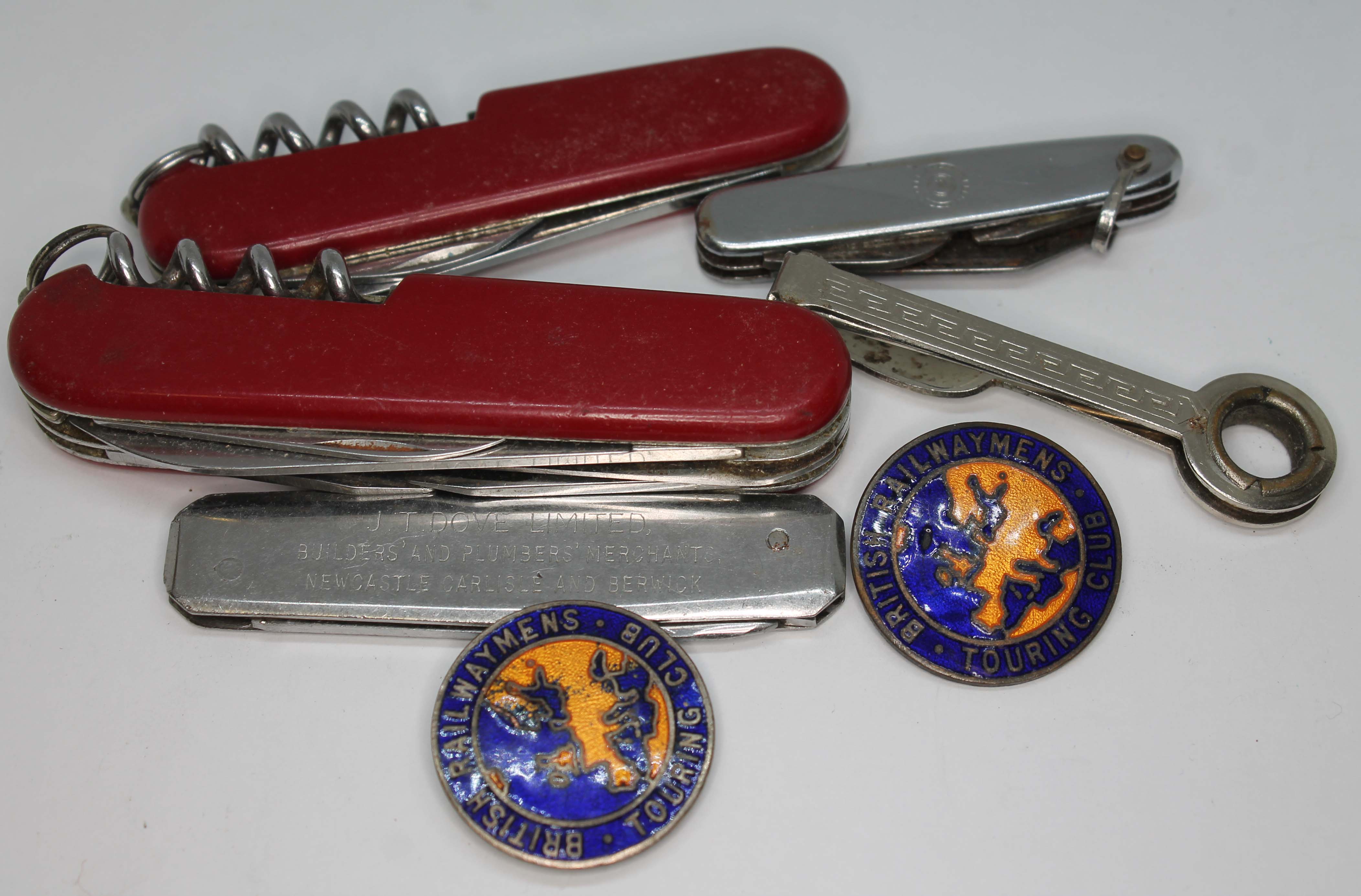 Three penknives and two British Railway enamel badges.