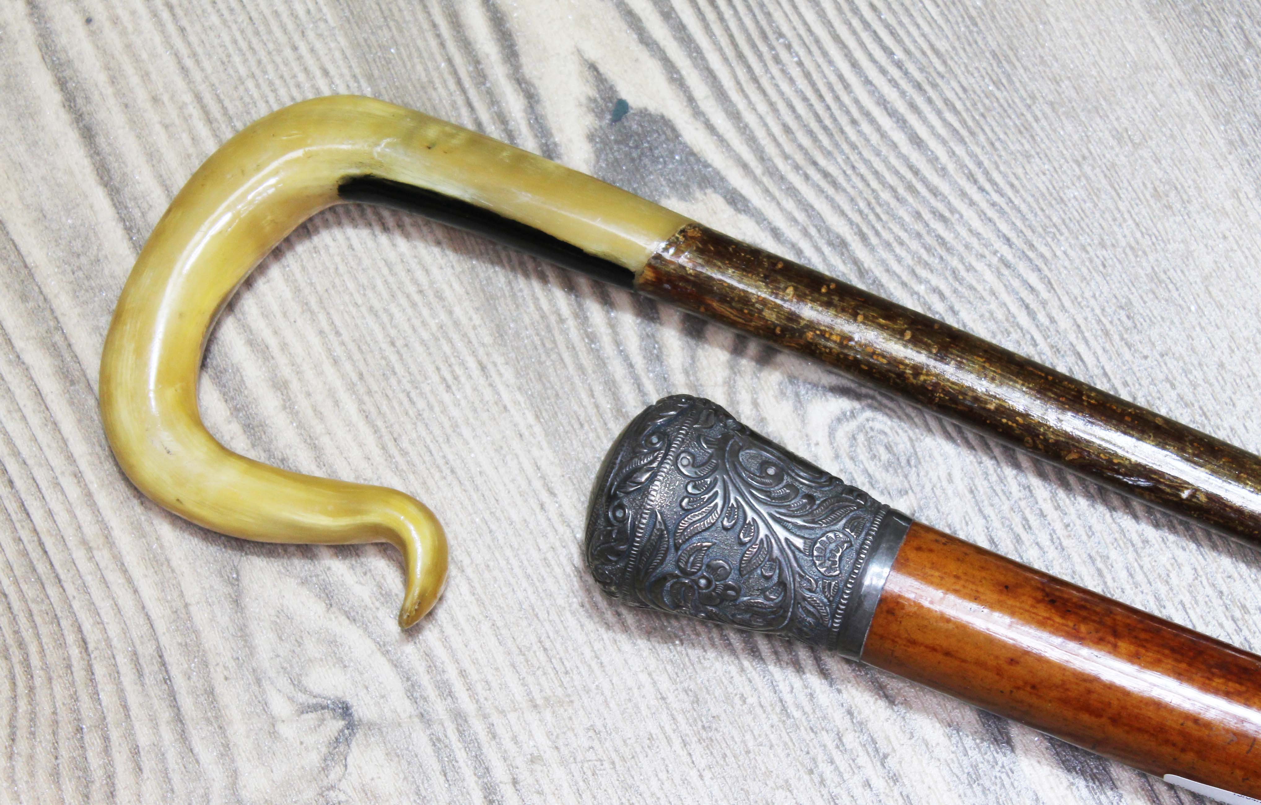A horn handled walking stick and a Victorian white metal handle walking stick.