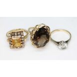 A group of three rings comprising two hallmarked 9ct gold set with quartz varieties and one white