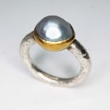 A contemporary silver ring by Poppy Dandiya, central bluish grey blister pearl set within a rub