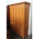 A 19th century pine linen press, arched panelled doors, two drawer base with Gothic style handles,