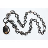 An antique tortoiseshell locket on graduated link chain, length 68cm. Condition - minor chips/