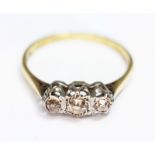 A three stone diamond ring, the stones weighing approx. 0.05, 0.10 and 0.05 carats, hallmarked