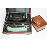 A vintage Bijou typewriter in case and an Italian inlaid cigarette box.