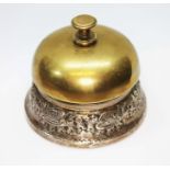 A white metal mounted brass desk bell, unmarked, diameter 8cm. Condition - various worn through