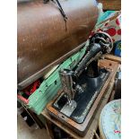 A hand cranked sewing machine in wooden case