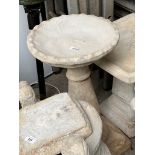 An crust edge birdbath on pedestal.