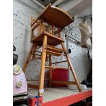 A child's wooden multipurpose high chair and a children's red pedal tractor