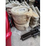 A pair of concrete urn planters on pedestals.