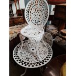 A cast metal garden table and two chairs