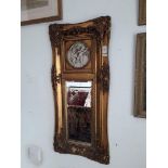 A vintage gilt framed mirror with plaster relief of cherubs, 39cm x 85cm overall.