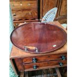 An Edwardian round mahogany tray with handles.