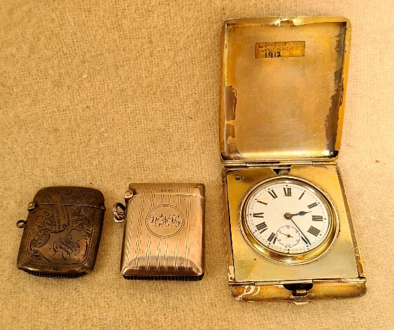 A silver pocket watch case holder, having hallmarks for 1912, London, a silver vesta case,
