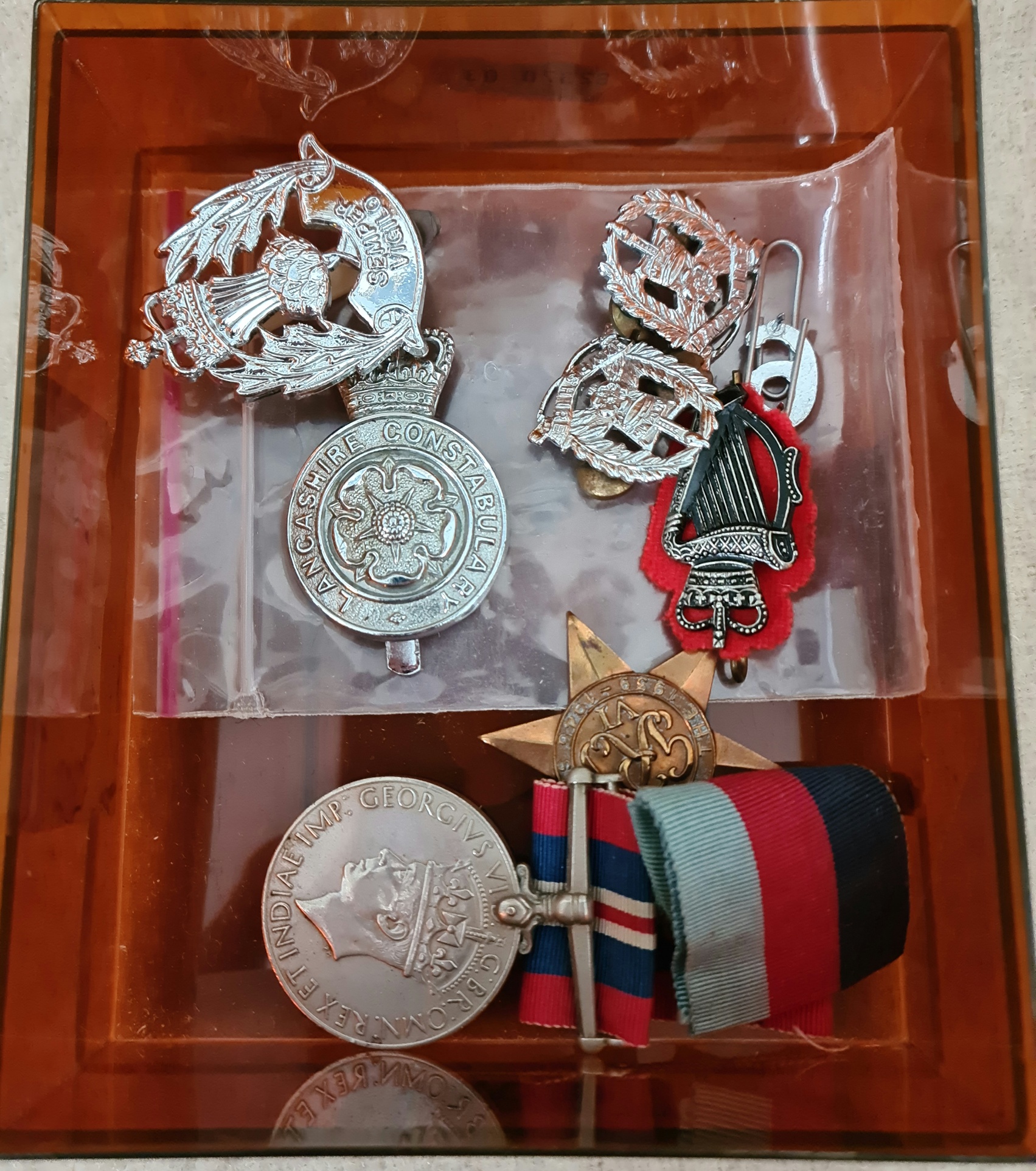 Two WW2 medals and assorted police badges.