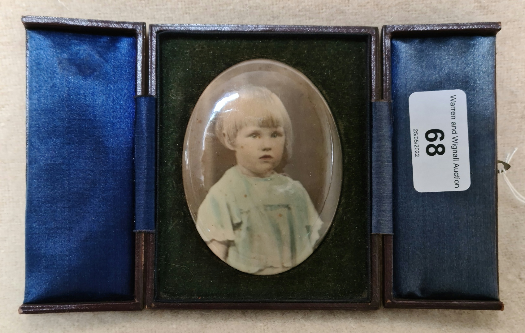 A vintage portrait of a child in leather case.
